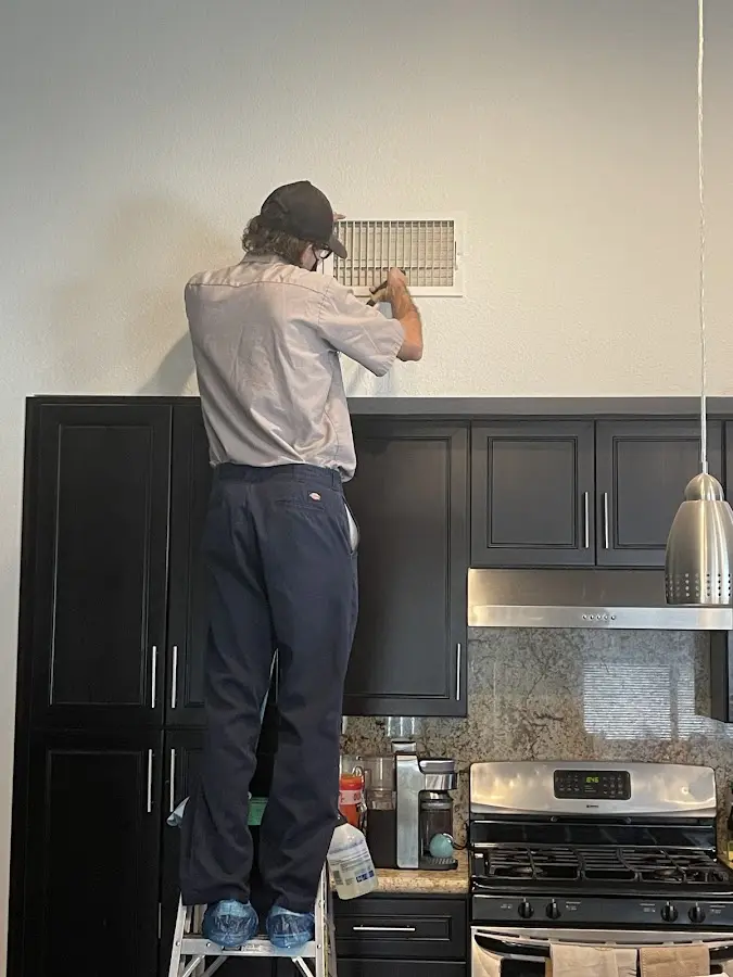 Technician inspecting an air vent during HVAC service in Incline Village